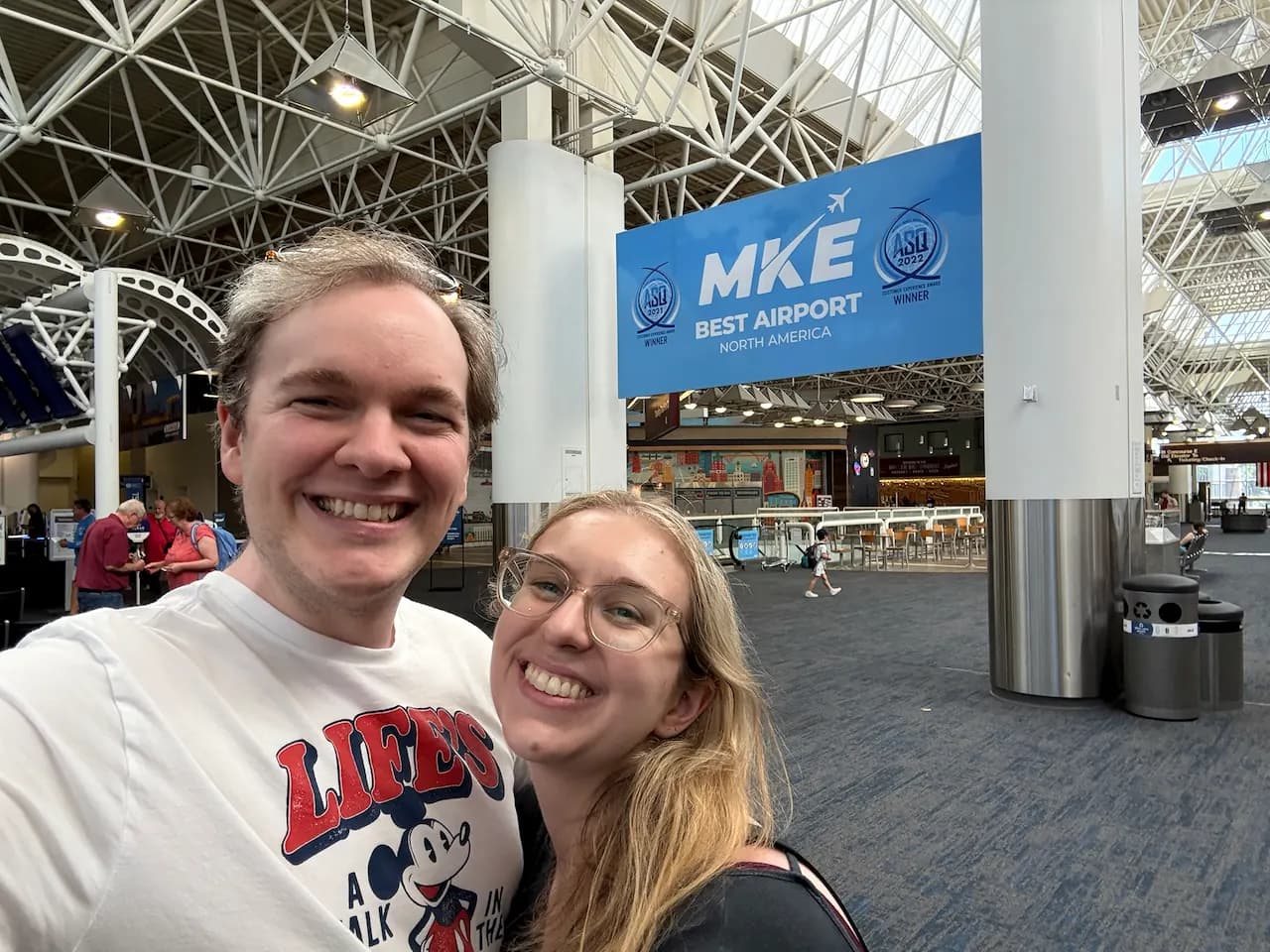 Jay and Gabi smiling together at Milwaukee Mitchell International Airport.