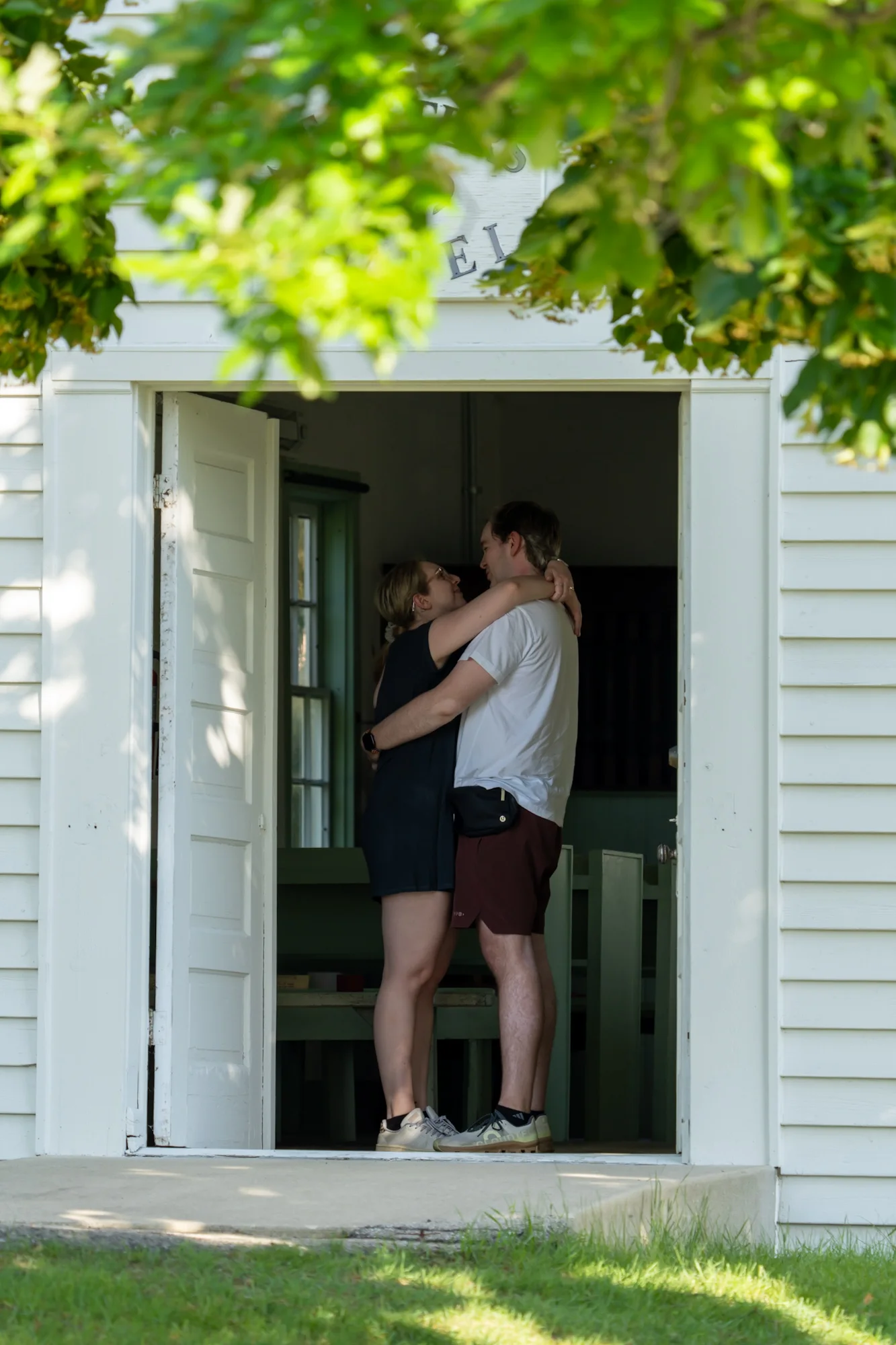 Jay and Gabi embracing in a sunlit doorway.