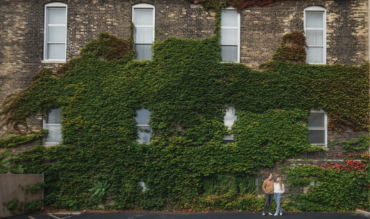 Gabriella and Jameson standing together in front of an ivy-covered brick building.